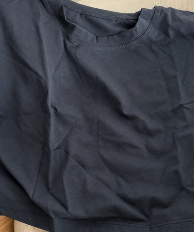 Detalhe da malha lisa, da gola redonda com ribana e da costura reforçada do ombro da camiseta cropped oversized feminina