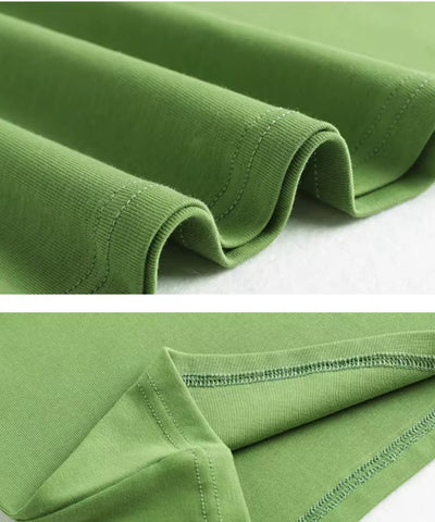 Detalhe do tecido 100% algodão dobrado da camiseta feminina manga curta verde, mostrando textura e acabamento