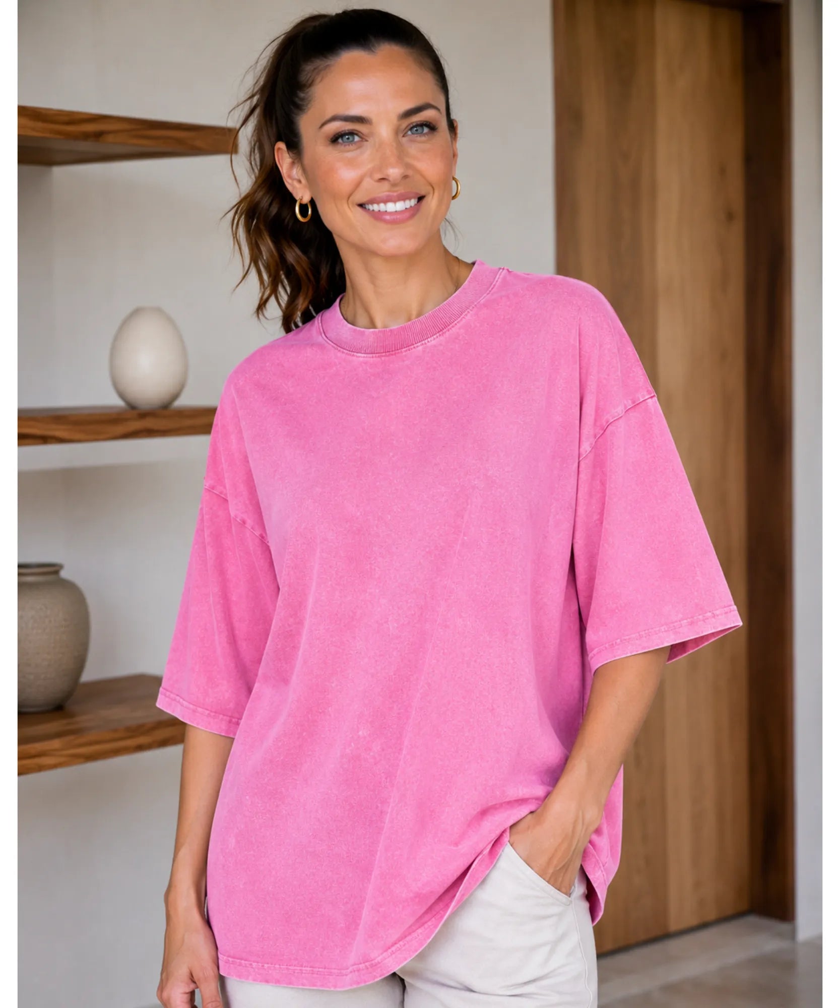 Camiseta oversized estonada 100% algodão cor rosa sendo usada por modelo, vista de frente