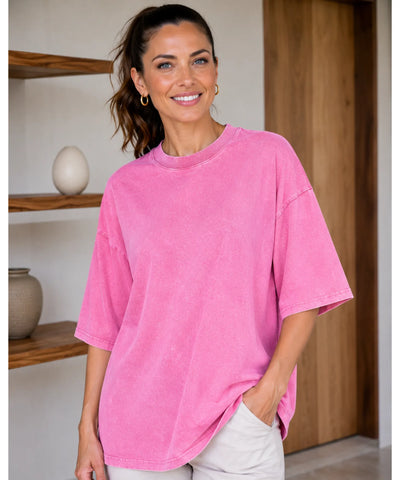 Camiseta oversized estonada 100% algodão cor rosa sendo usada por modelo, vista de frente