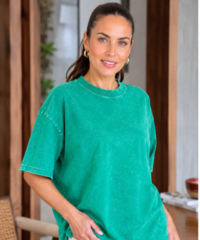 Camiseta oversized estonada 100% algodão cor verde brilhante, close-up mostrando textura estonada do tecido