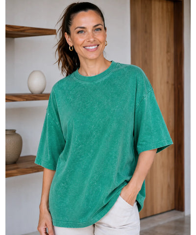 Camiseta oversized estonada 100% algodão cor verde brilhante sendo usada por modelo, vista de frente