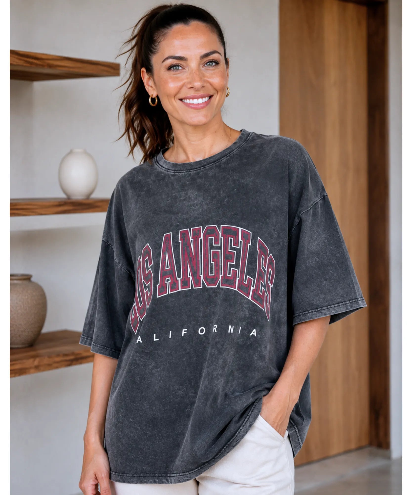 Camiseta oversized feminina preta estonada estampa Los Angeles California, modelo sorrindo de frente