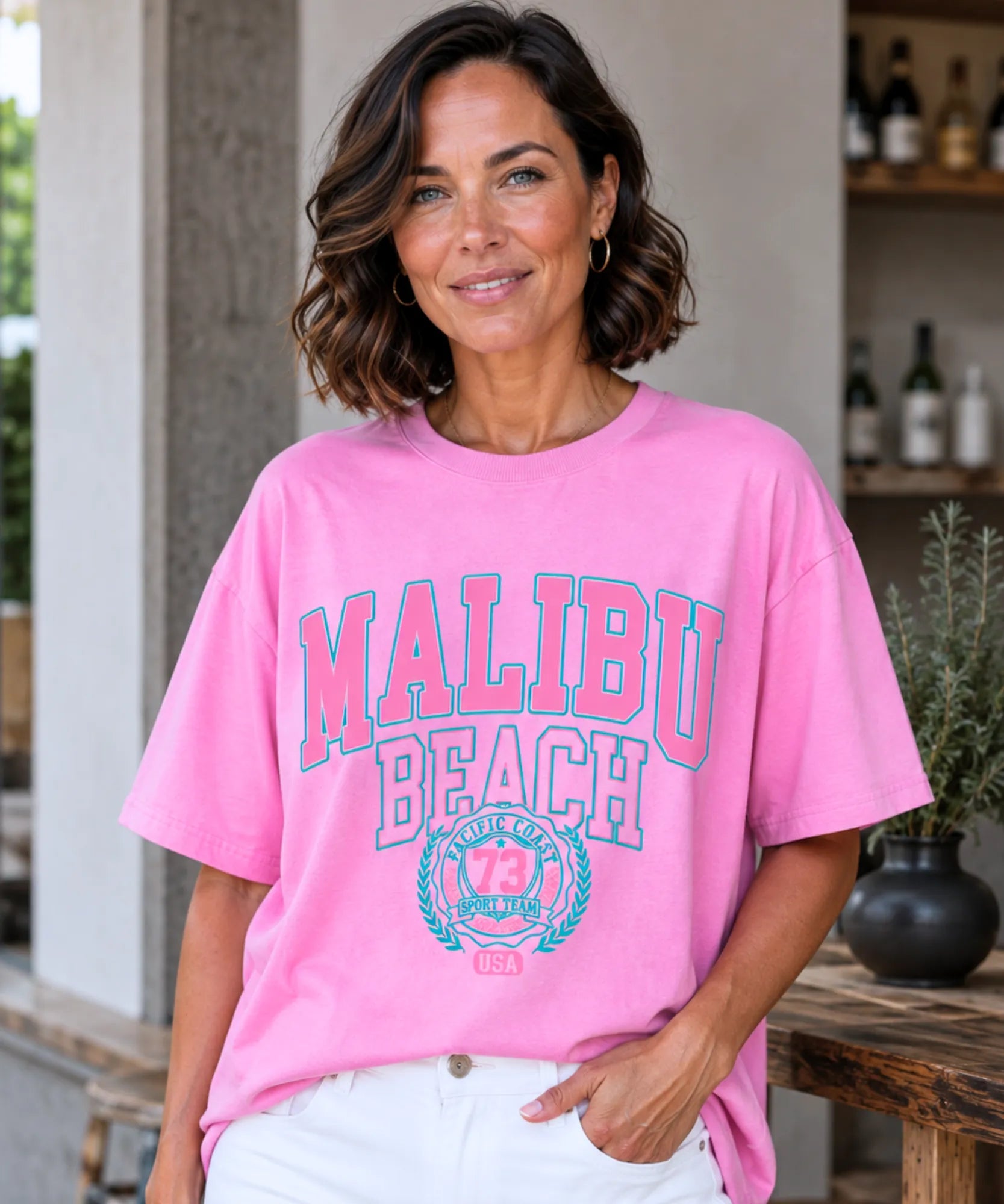 Camiseta oversized feminina rosa vista de frente, modelo sorrindo