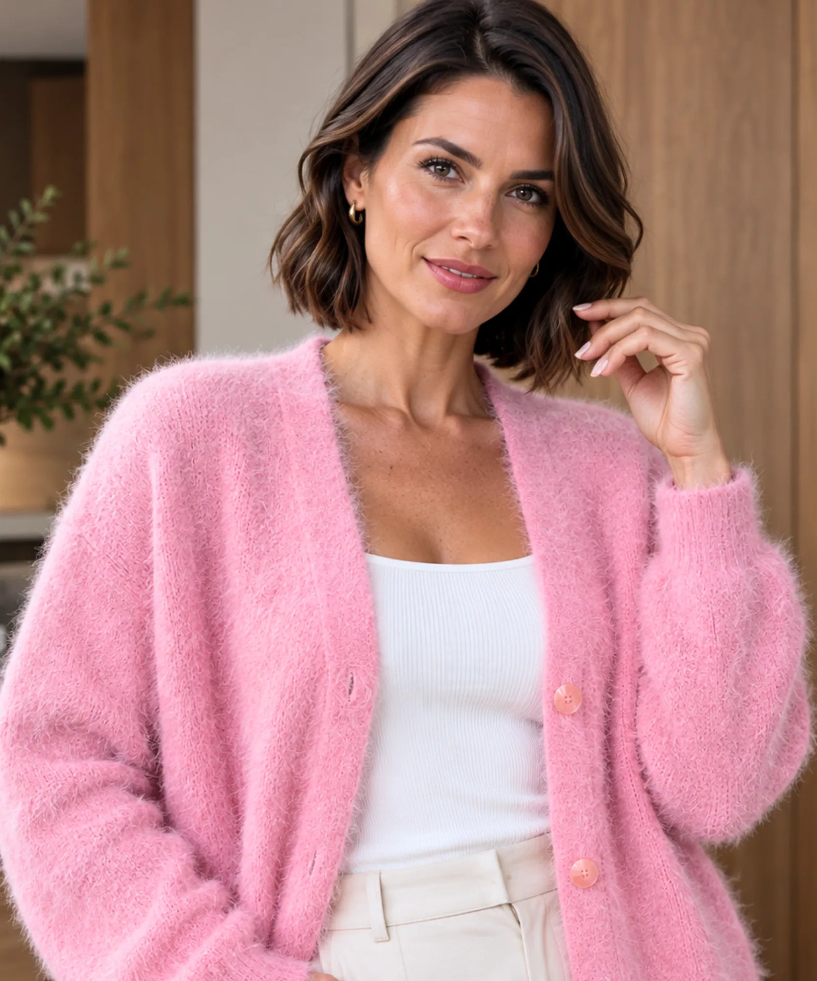 Cardigan feminino rosa de tricot pelúcia, close nos botões frontais