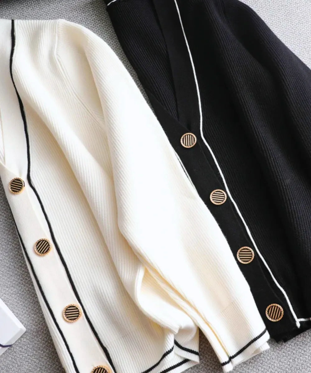 Detalhe dos botões dourados e do vivo contrastante do cardigan tricot feminino nas cores branco e preto