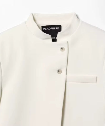 Detalhe da gola padre, dos botões forrados e do bolso chapado do casaqueto off white