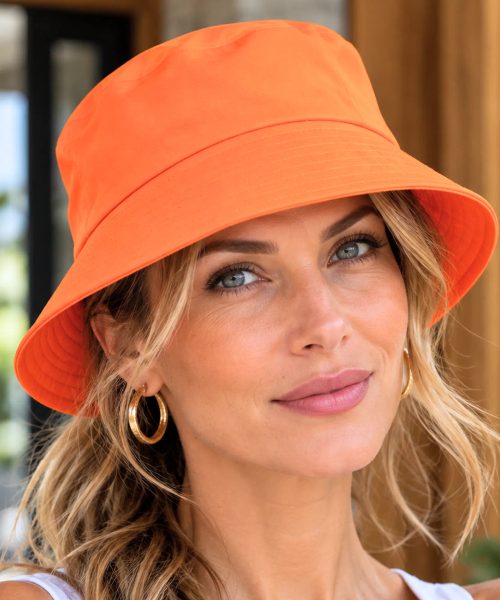 Chapéu bucket de algodão na cor laranja, modelo usando em ambiente externo