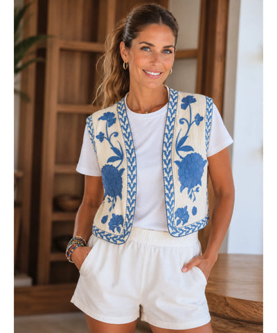 Colete feminino bordado floral bege com bordado azul, modelo vestindo short branco