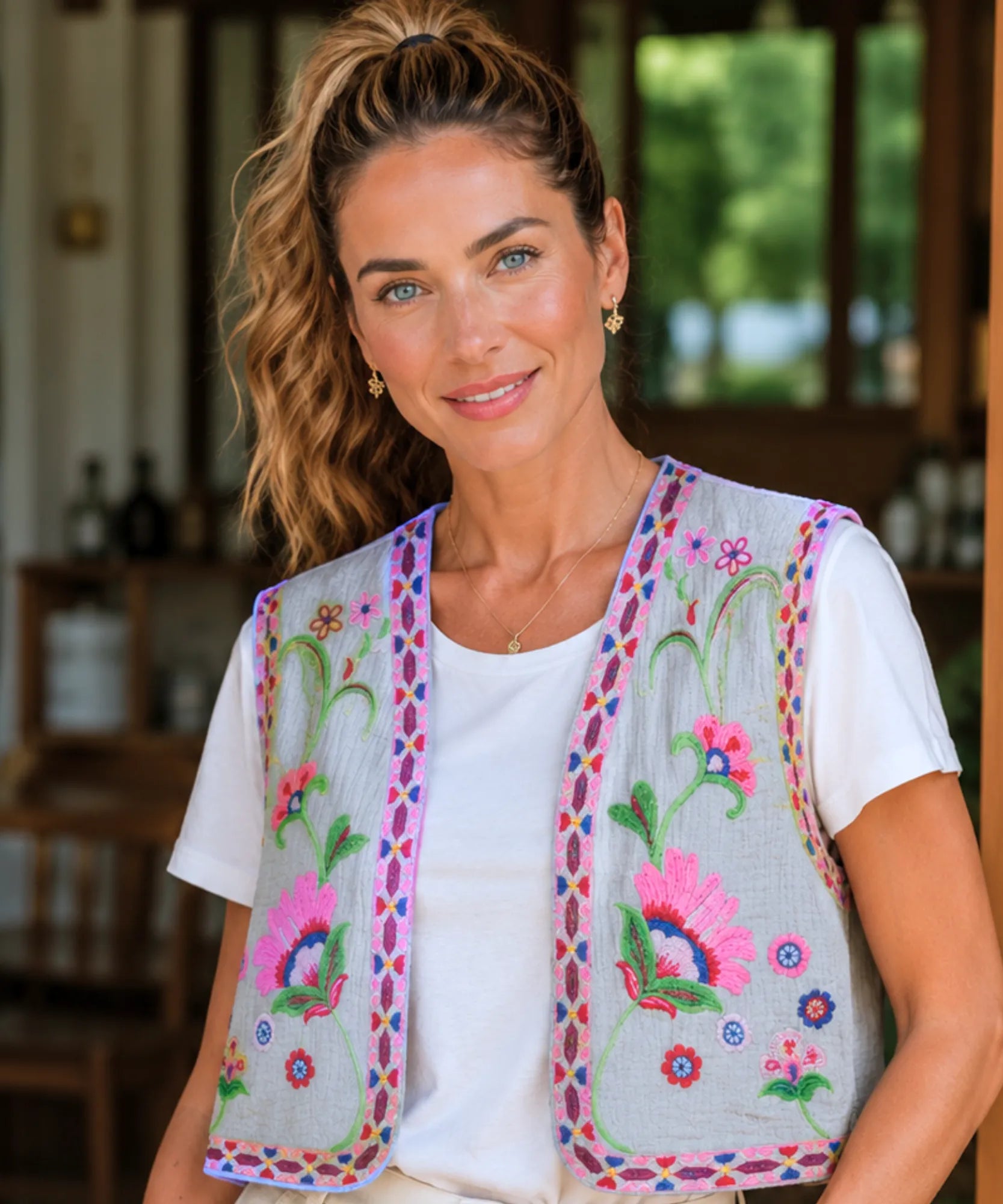 Colete feminino bordado floral cinza com bordado colorido, modelo vestindo camiseta branca