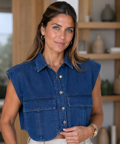 Colete jeans feminino curto cropped azul escuro sem manga, aberto sobre calca de cintura alta