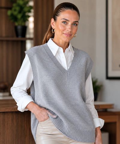 Colete feminino tricot cinza oversized com mão no bolso da calça bege
