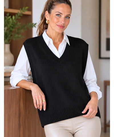 Colete feminino tricot preto oversized, modelo apoiada em balcão de madeira