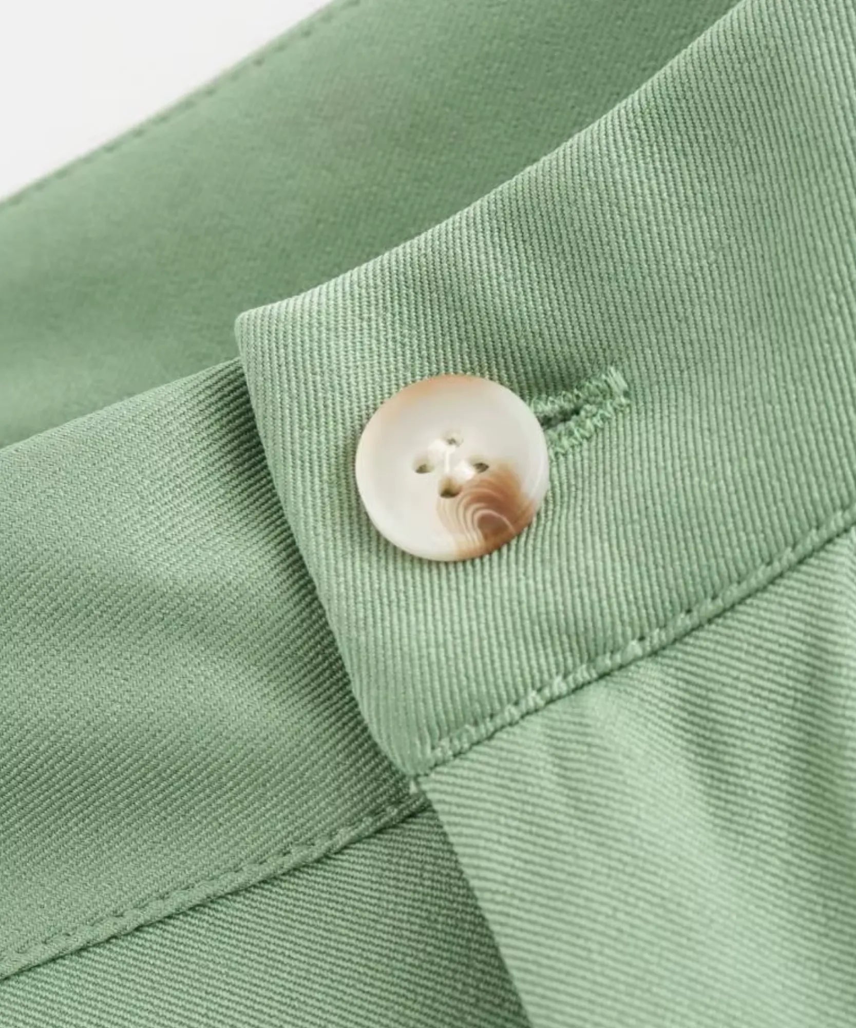 Colete alfaiataria feminino verde oliva, detalhe do botão e da gola