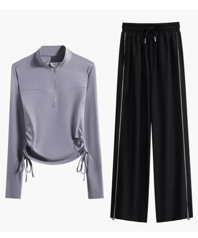 Blusa lilás de meio zíper e calça pantalona preta em still de produto