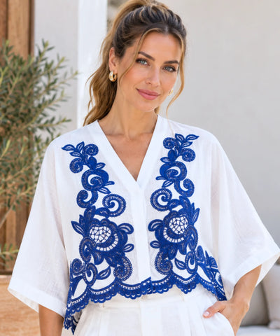 Blusa branca bordada em azul com manga morcego e decote em V
