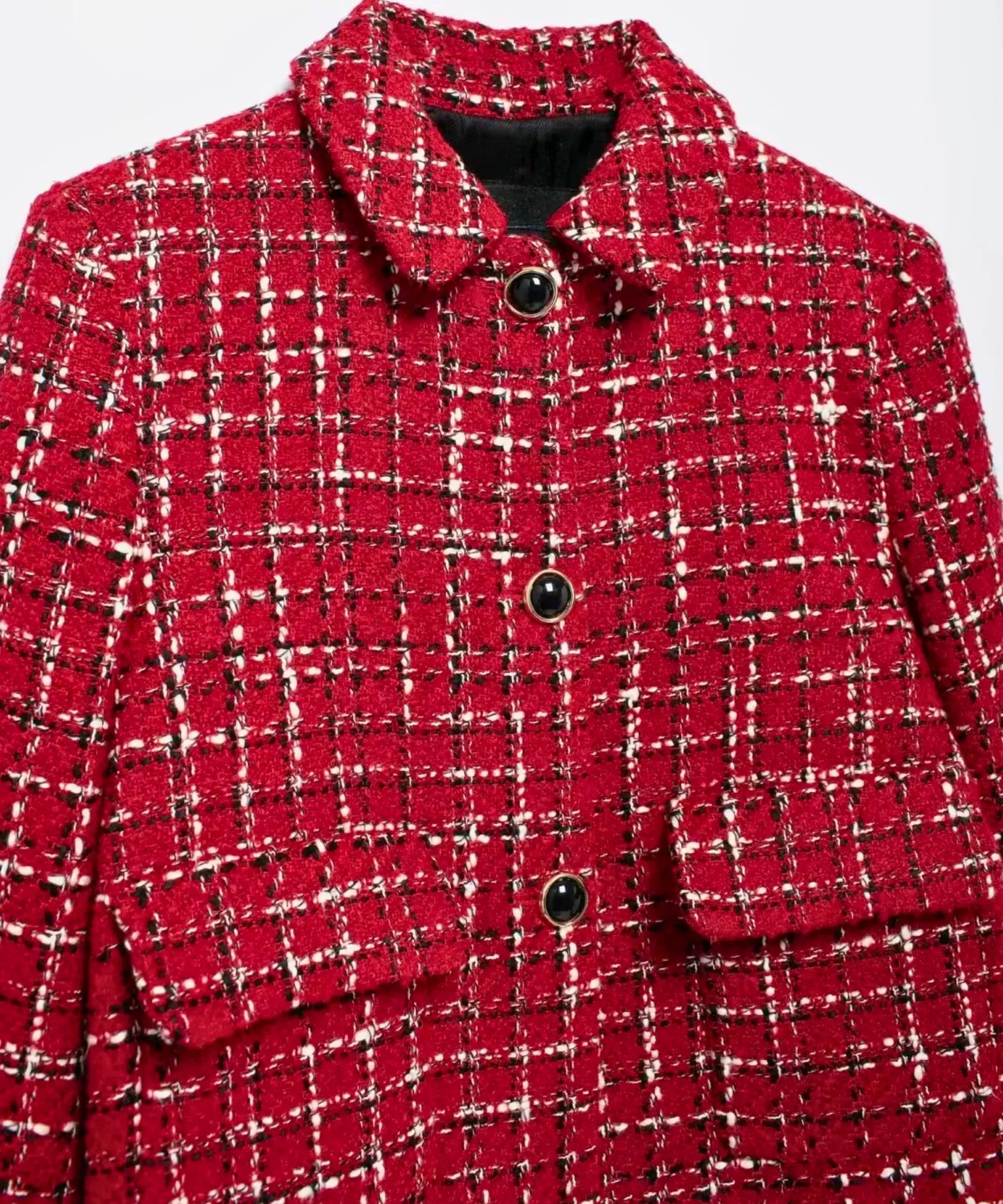 Detalhe da trama do tweed xadrez vermelho com botoes pretos de aro dourado e bolso com pala
