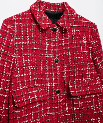 Detalhe da trama do tweed xadrez vermelho com botoes pretos de aro dourado e bolso com pala
