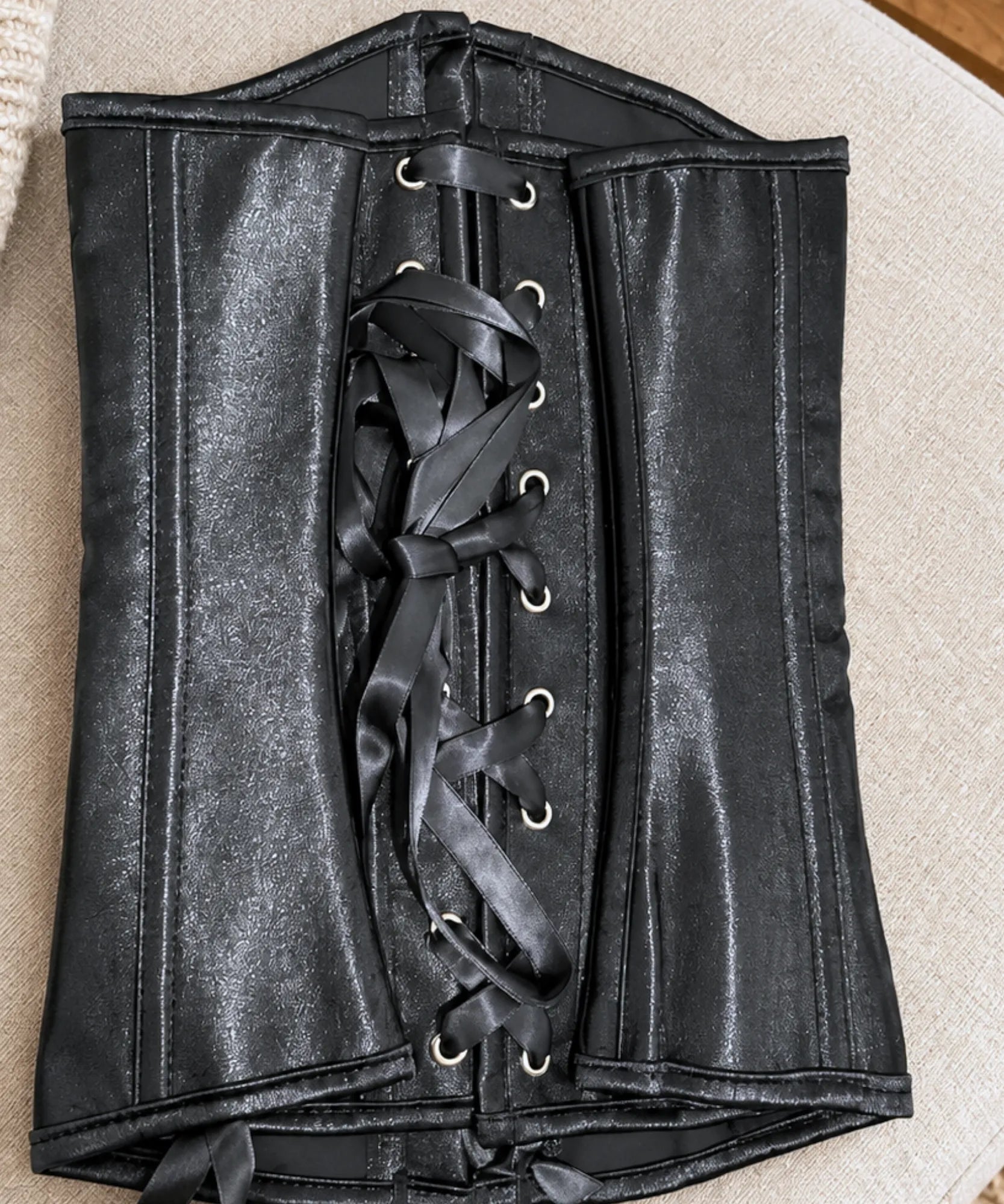 Corset feminino cetim preto, detalhe da amarração traseira e ilhoses
