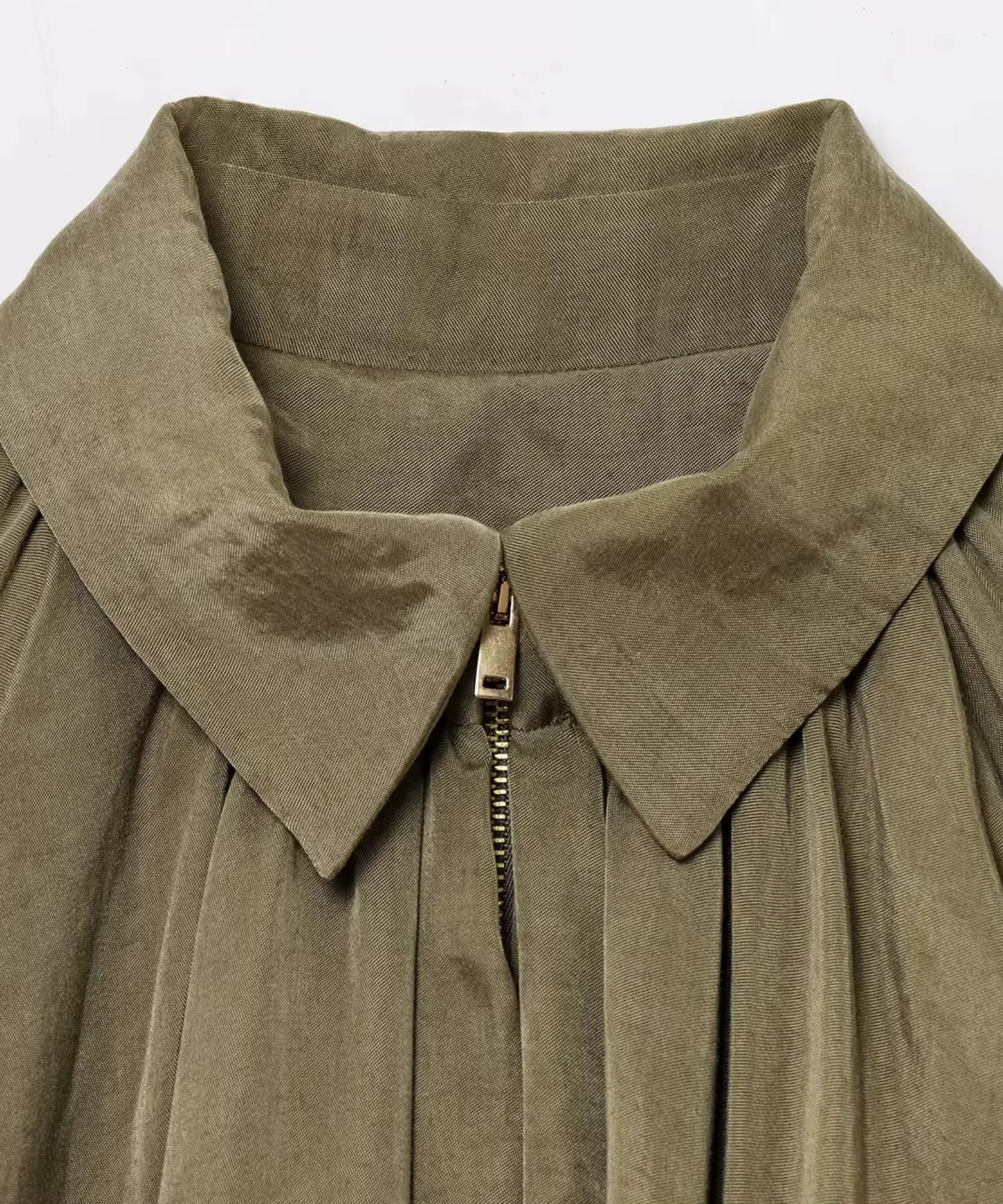 Detalhe do zíper dourado e colarinho da jaqueta oversized feminina verde militar