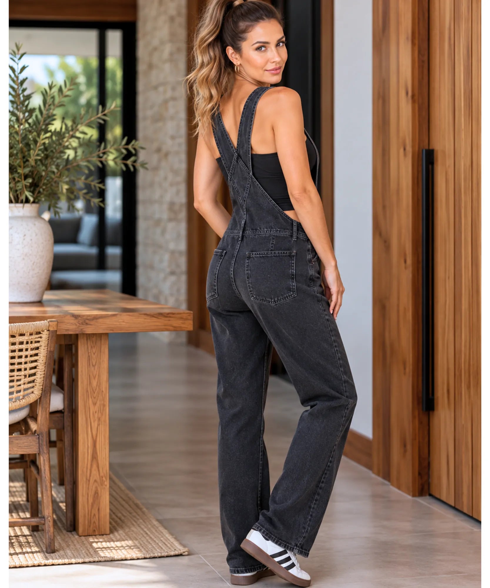Macacão jardineira jeans preto, vista de costas em pé