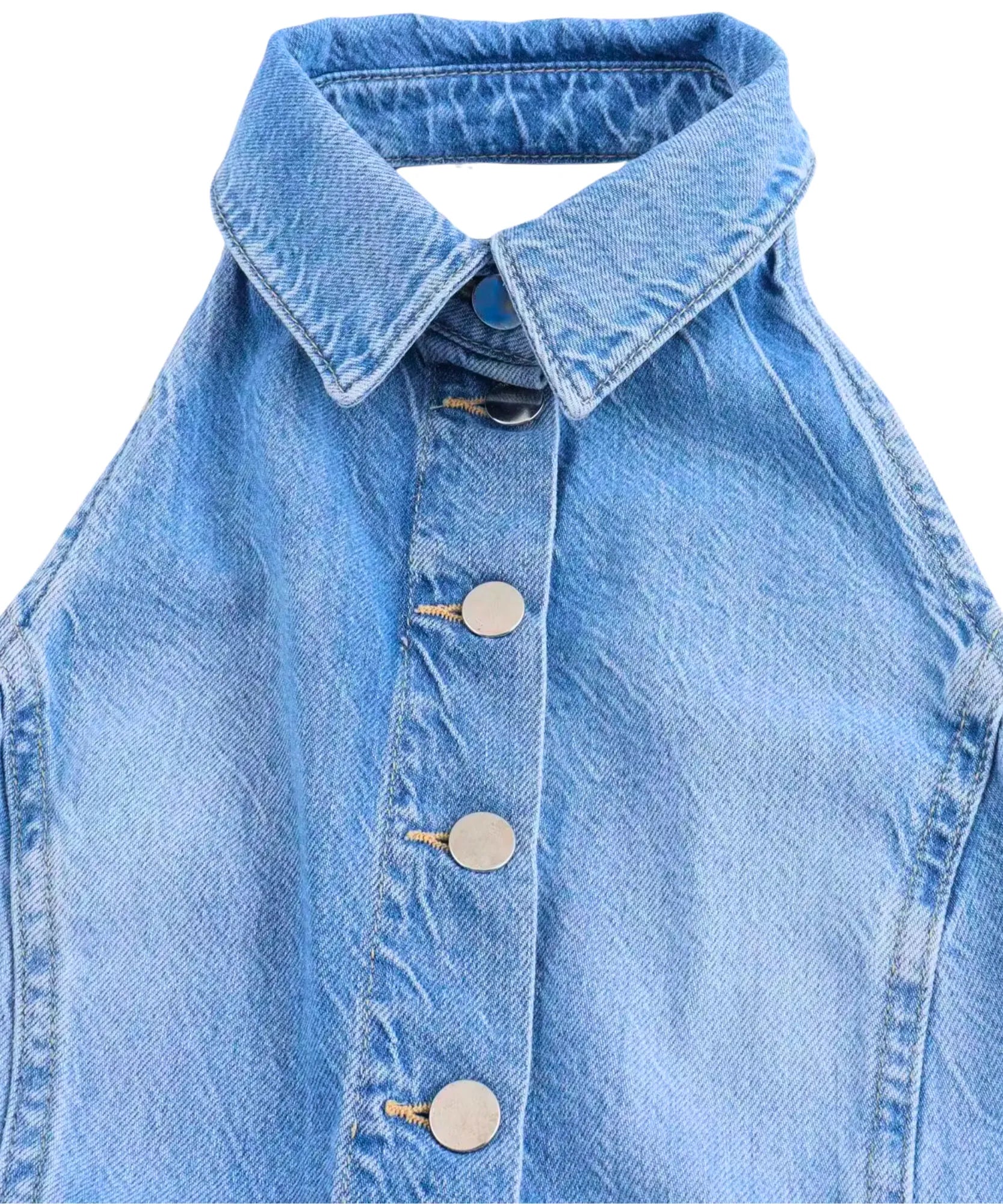 Detalhe macro da gola camisa e dos botões metálicos frontais do macacão jeans pantalona feminino