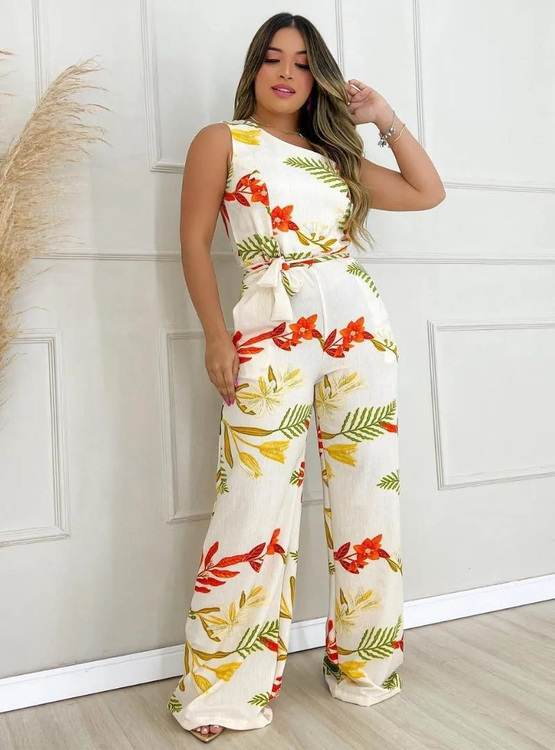 Mulher usando macacão longo de um ombro só com estampa floral, tecido crepe e modelagem pantalona.
