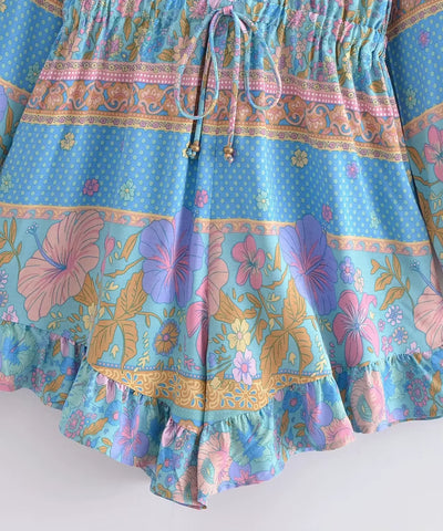Detalhe da barra com babado do macaquinho feminino azul estampado