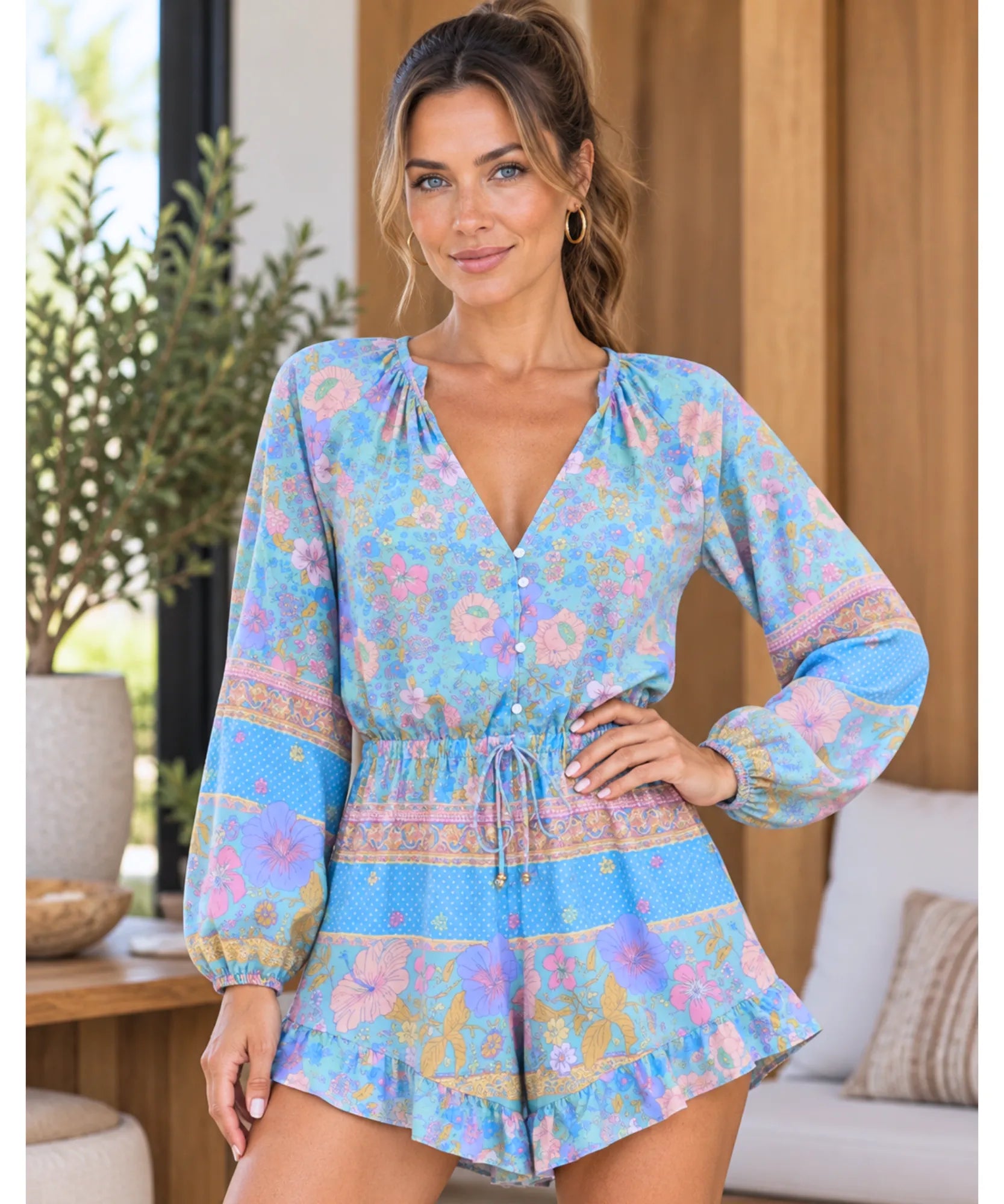 Modelo usando macaquinho feminino azul estampado com manga longa bufante e decote V