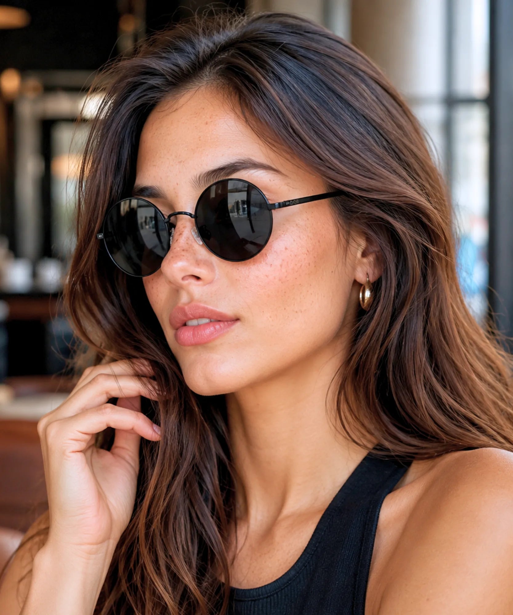 Óculos de sol redondo feminino com armação preta e lente preta em look de regata preta | Allore Anellimn