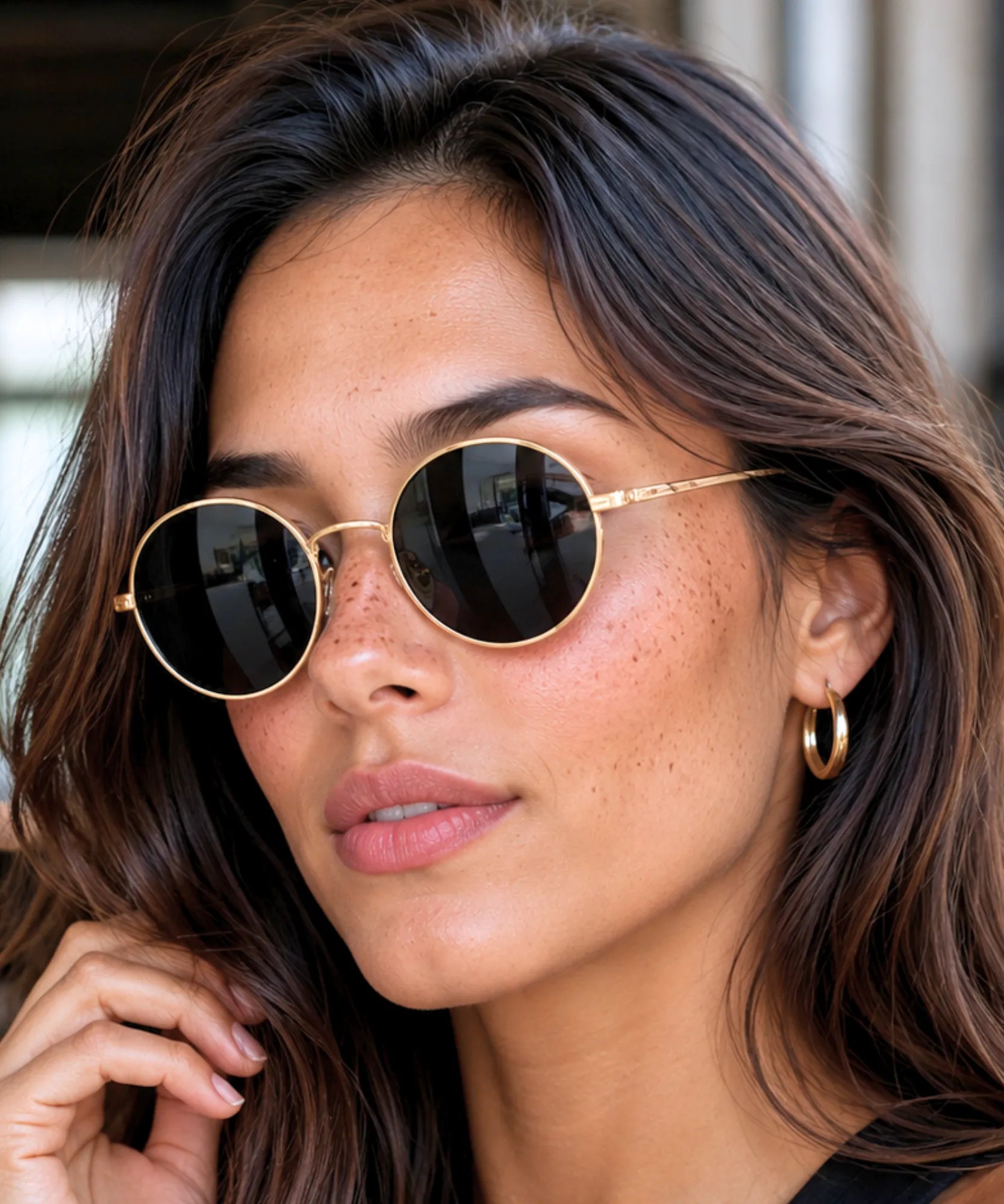 Óculos de sol redondo feminino polarizado com armação de metal dourado e lente preta na modelo — cor Preto e Dourado | Allore Anellimn