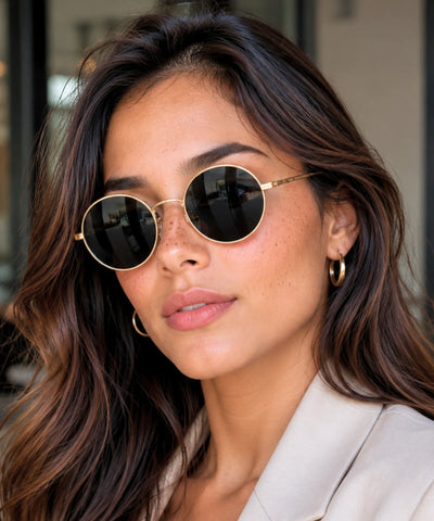 Óculos de sol redondo feminino vintage dourado com lente preta polarizada em close frontal | Allore Anellimn