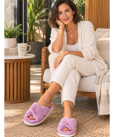 Modelo de corpo inteiro sentada em look off white usando pantufa aberta feminina de pelúcia cinza escuro