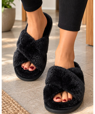 Pantufa aberta feminina de pelúcia preta usada com legging, sobre piso de sala