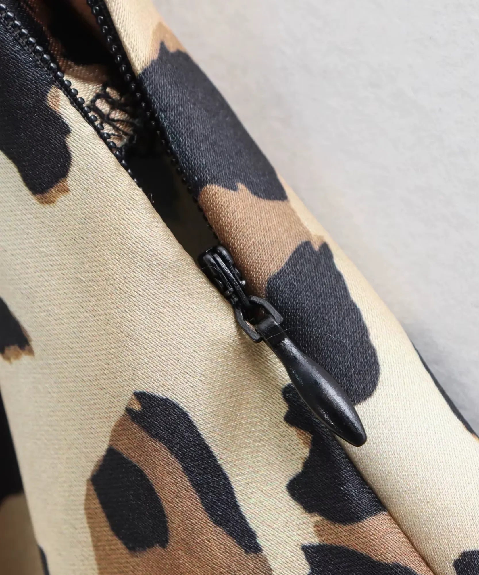Detalhe do zíper da saia longa animal print caramelo
