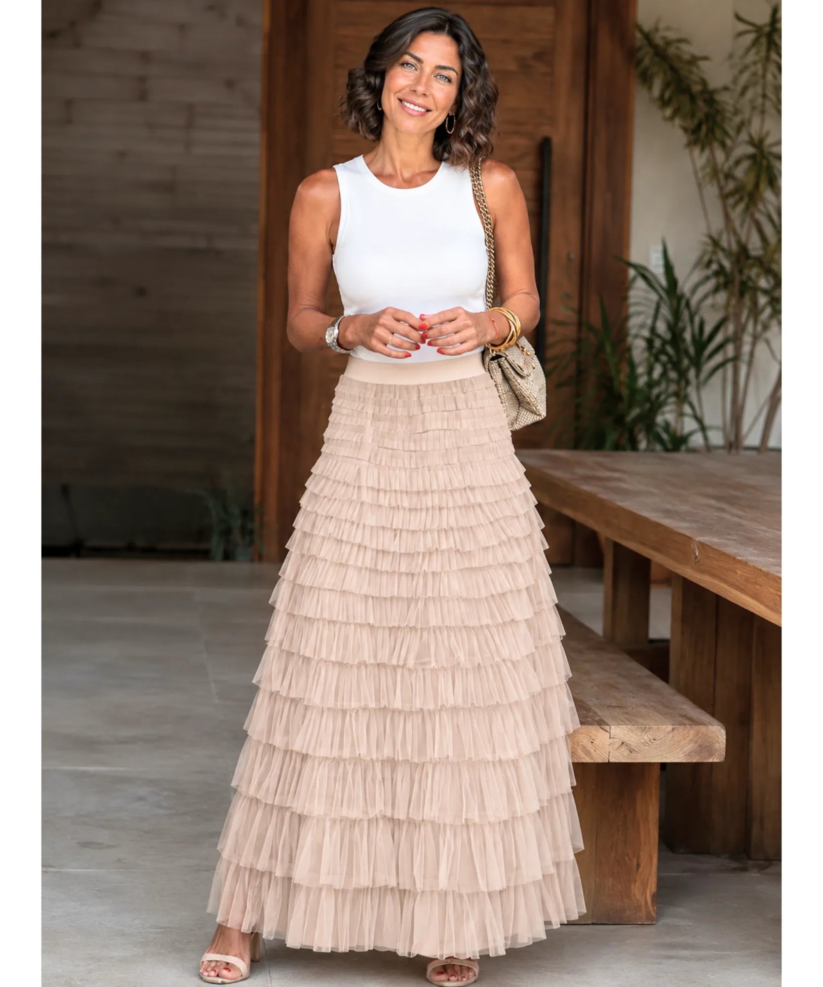 Mulher usando saia longa tule babados bege com bolsa