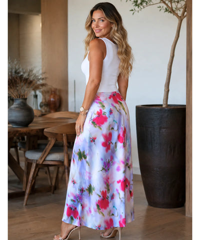Detalhe da fenda lateral da saia midi floral em cetim lilás com estampa floral rosa e verde