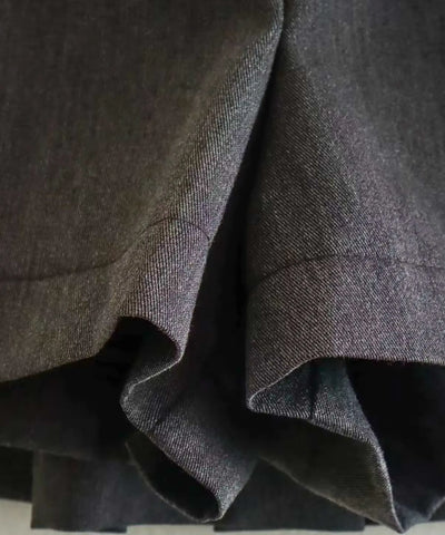 Detalhe das pregas estruturadas do shorts saia preto alfaiataria