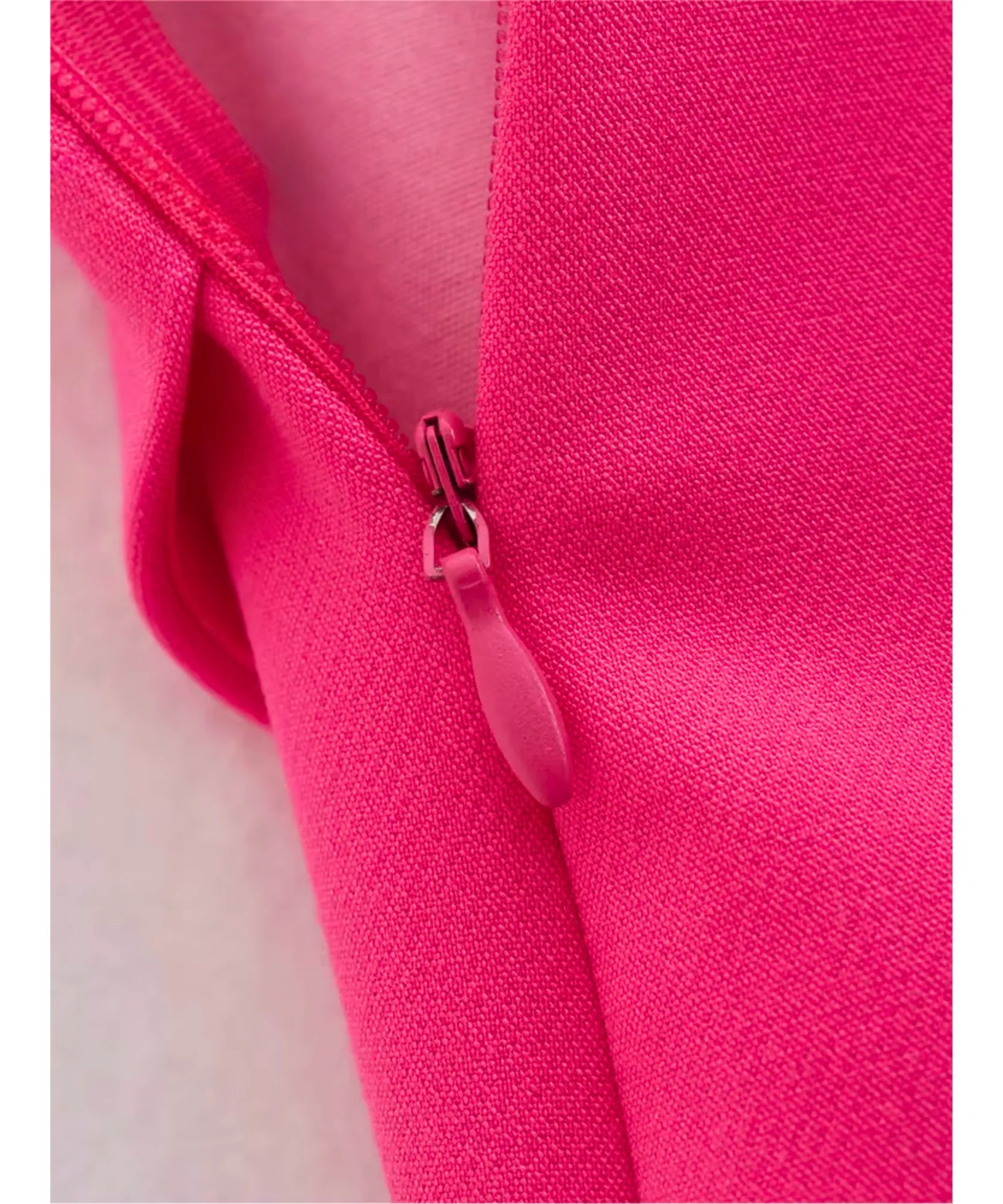 Detalhe do zíper lateral invisível do shorts saia feminino alfaiataria rosa