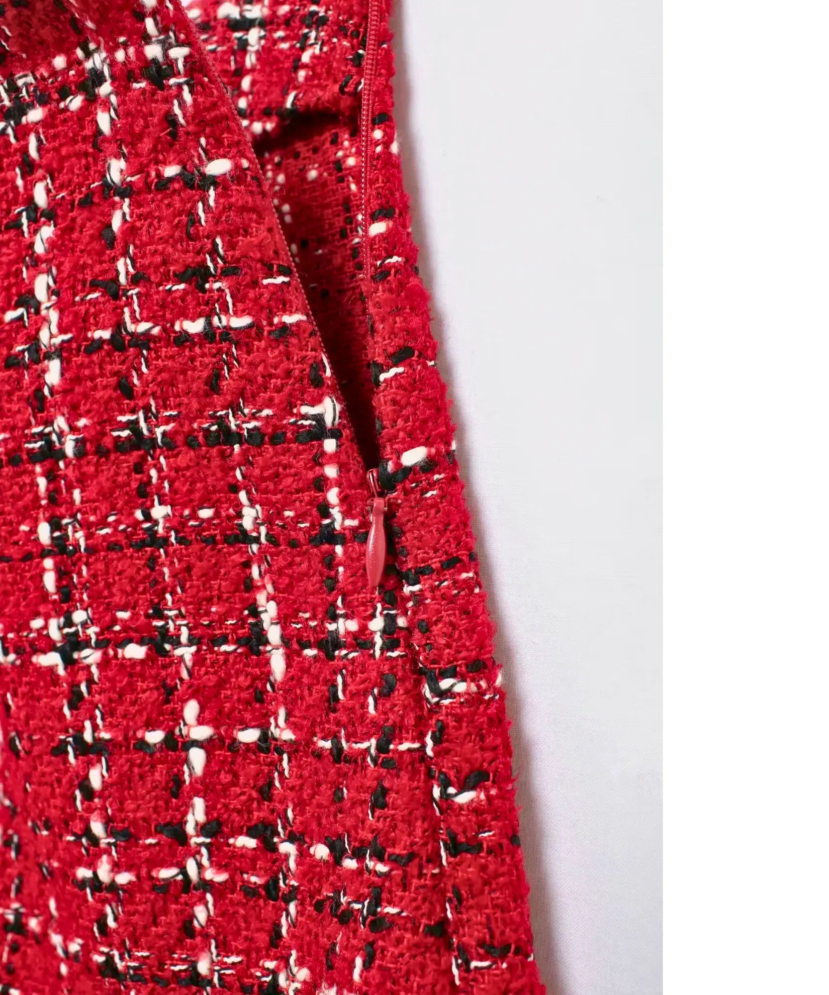 Detalhe do ziper invisivel lateral da shorts-saia de tweed xadrez vermelho