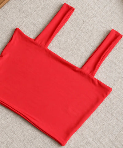Top cropped vermelho fotografado aberto, mostrando as alças largas e o corte sem bojo