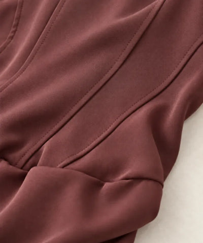 Detalhe dos recortes de corset no busto do vestido marrom