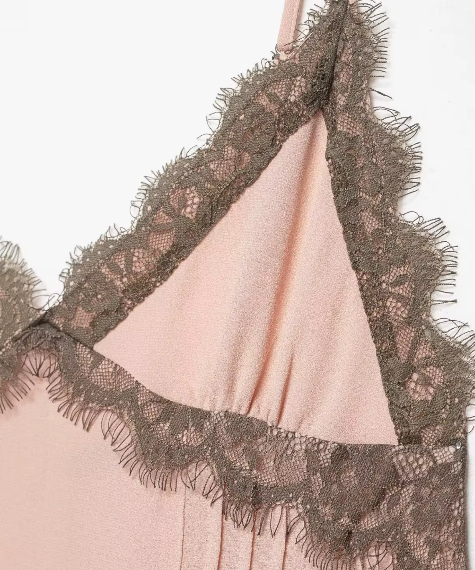 Detalhe da renda contrastante no decote em V do vestido rosa