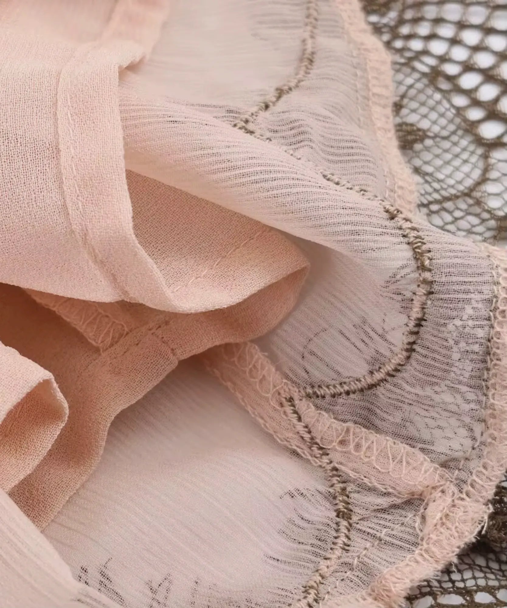 Detalhe do tecido leve e da renda da barra do vestido rosa