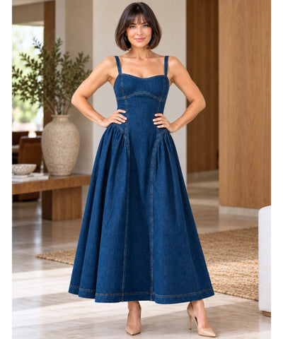 Vestido jeans longo azul de frente com as mãos na cintura