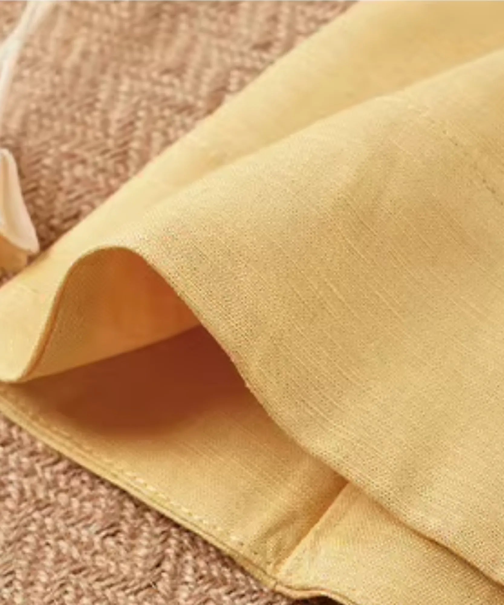 Detalhe da bainha do vestido de linho curto amarelo