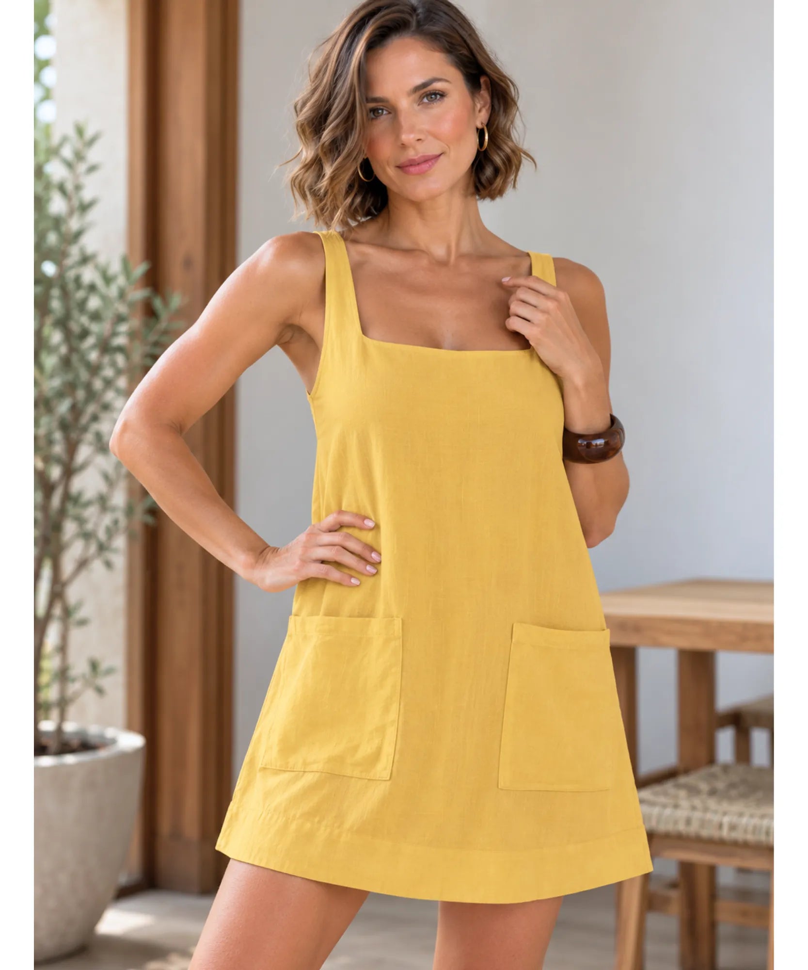 Vestido de linho curto amarelo, modelo de frente em outra pose