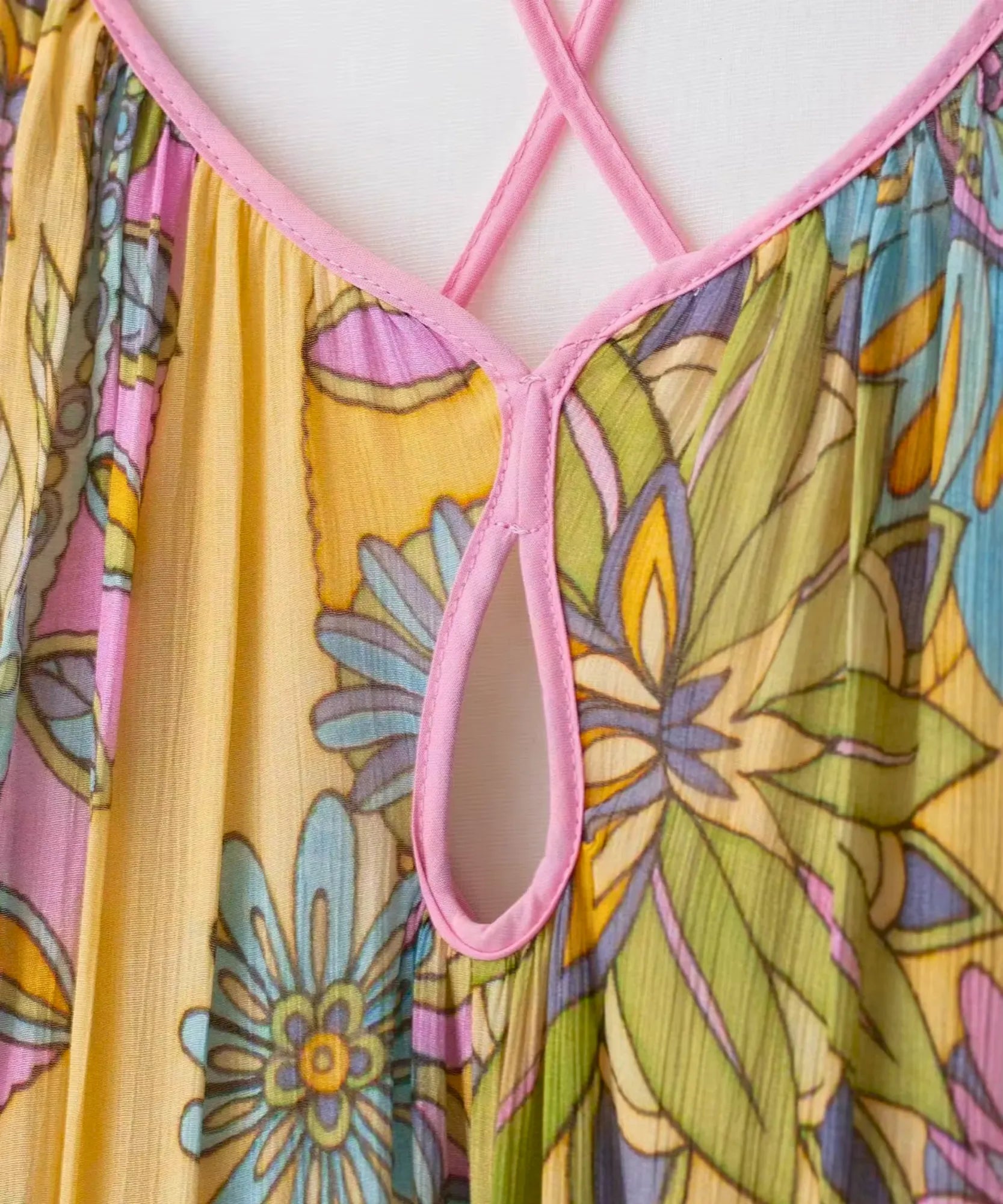 Detalhe do decote V e da estampa floral do vestido longo amarelo