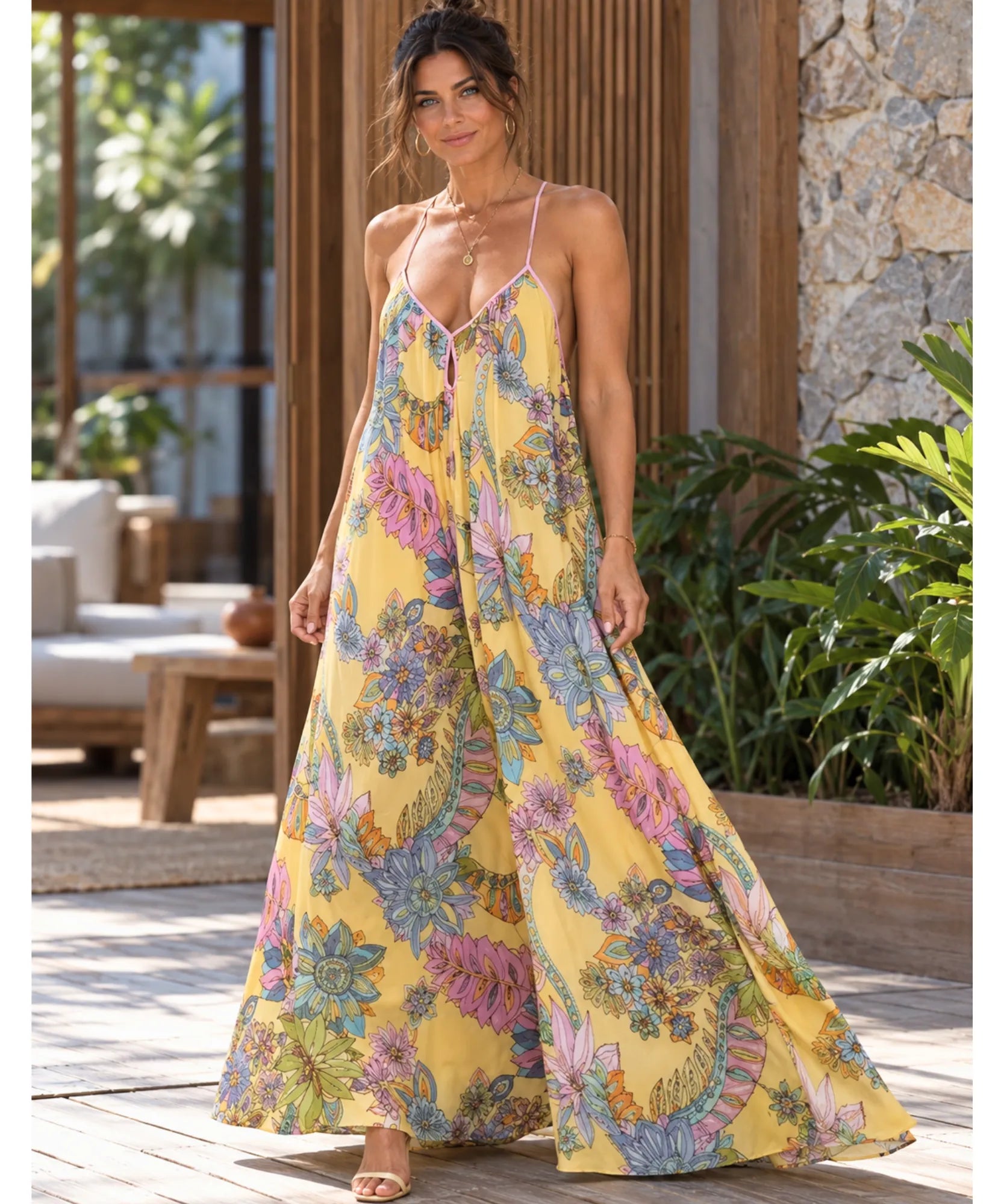 Vestido longo floral amarelo com alças finas, modelo de frente caminhando
