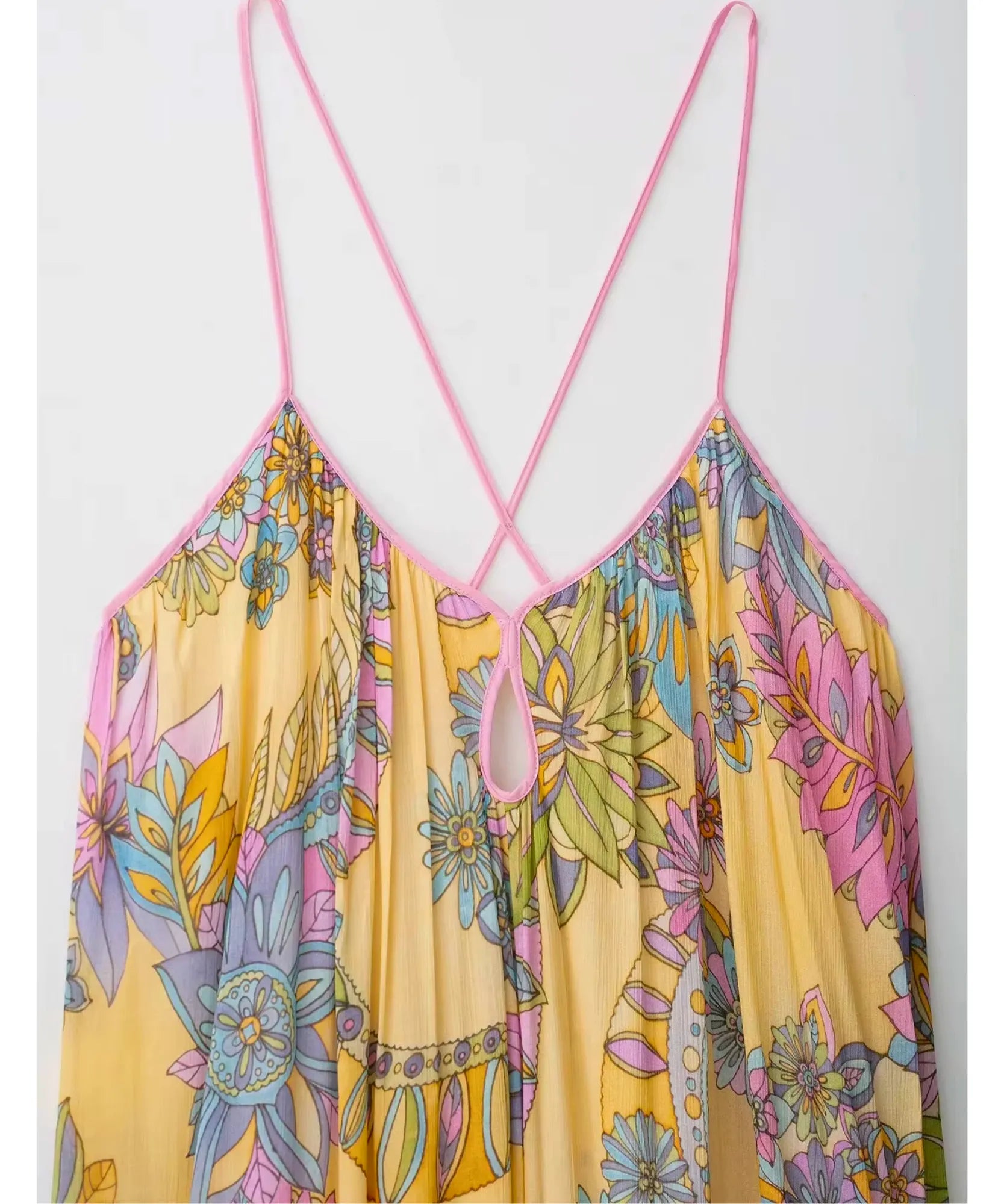 Detalhe das alças finas cruzadas do vestido longo floral amarelo